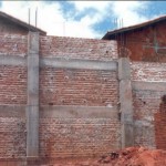 encosta protegida por grande muro de proteção de arrimo feita com tijolos maciços e vigas de concreto