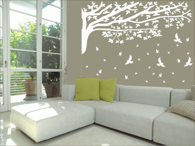 Sala de estar com sofá de canto decorada com adesivos da natureza