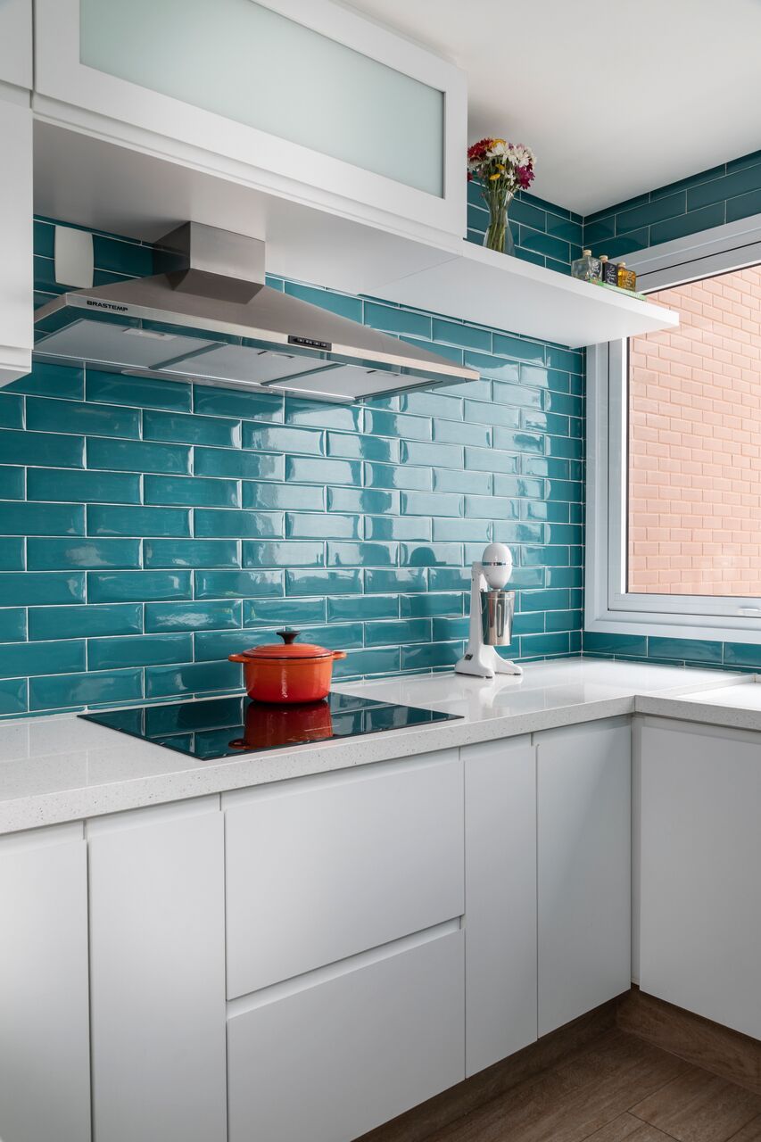 Cozinha moderna com paredes azul turquesa e móveis brancos