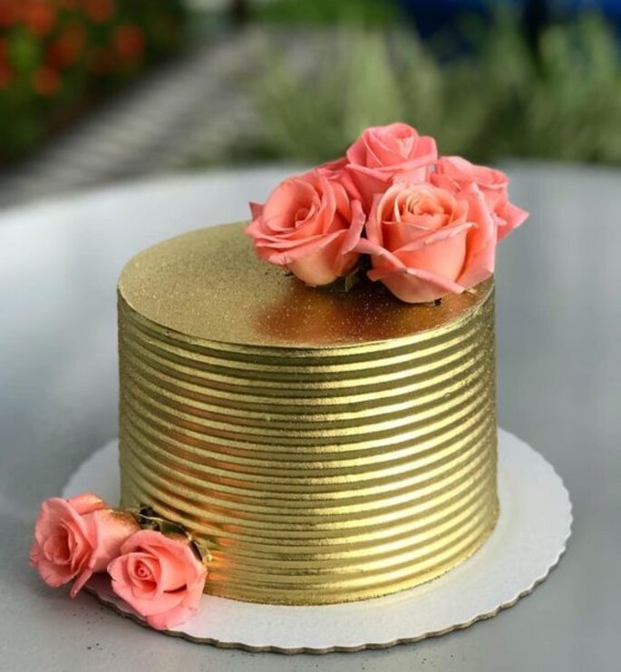 O bolo de férias é decorado com bolas douradas, brilhos dourados e  macaroons pretos bolo de aniversário masculino 60 anos fechar